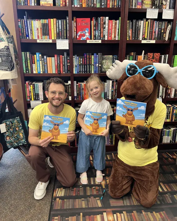 Mr B with a young reader and the Hoose Moose mascot in a bookstore