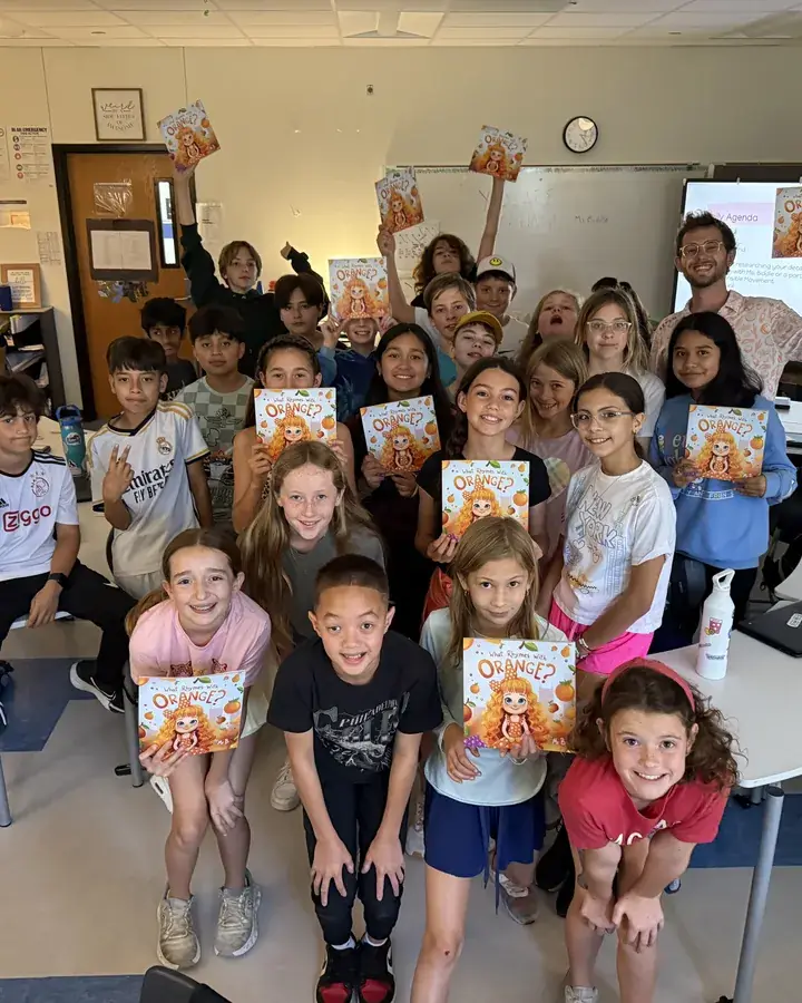 A class holding up copies of What Rhymes With Orange?