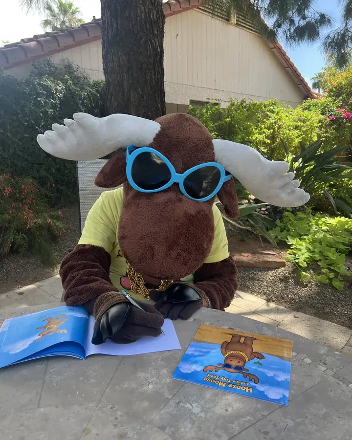 The Hoose Moose mascot with the book